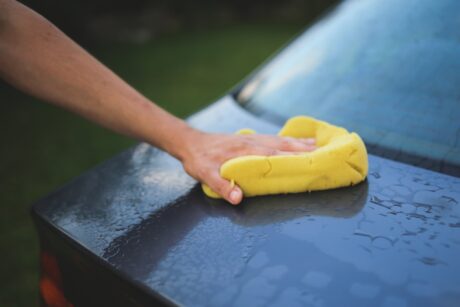 Man cleaning a car -- he should've read our top 5 car cleaning tips!