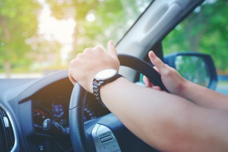 Picture showing someone driving with hands on the steering wheel