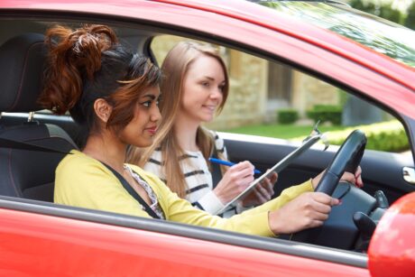 A female driving instructor teaching a learner driver.