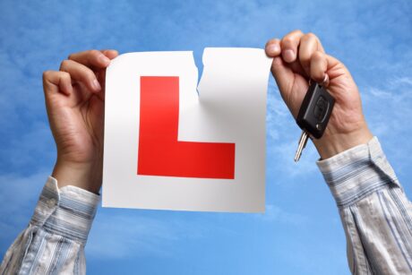 A man tearing up his L-plate, symbolising that exciting moment when you pass your test.