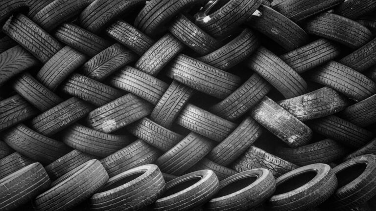 A wall of used car tyres. Tyres are one of the most common car maintenance replacement parts.