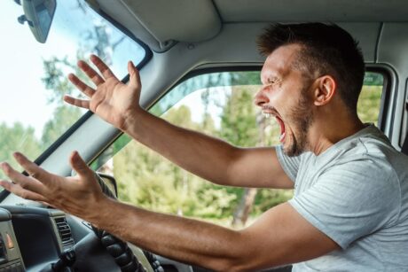 An angry man driving his car, symbolising road rage.