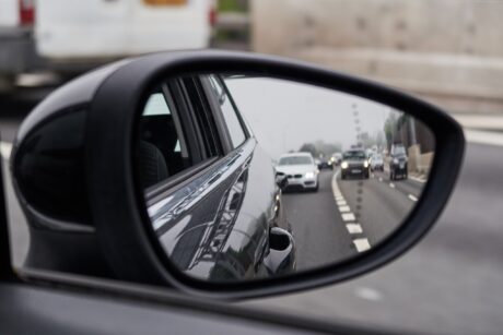 A car door mirror showing lanes of traffic behind. Learning to use your mirrors safely is part of the MSPSL routine.